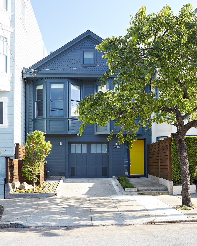 Small and blue victorian two floor detached house in San Francisco with wood cladding and a pitched roof.