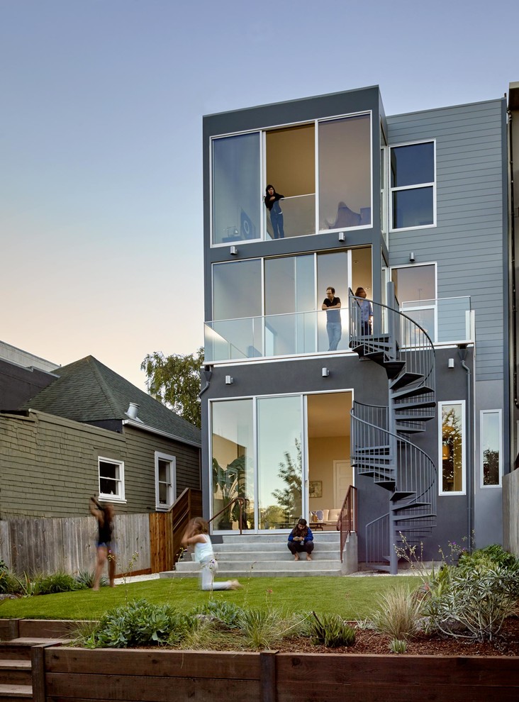 This is an example of a large and blue modern detached house in San Francisco with wood cladding, a flat roof, a metal roof and three floors.