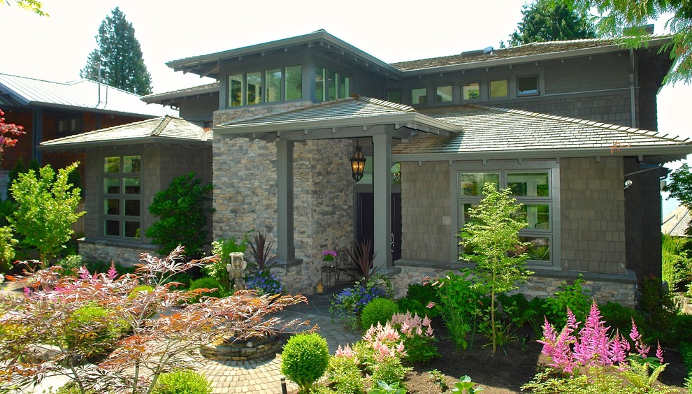 Large and gey traditional house exterior in Vancouver with three floors and mixed cladding.