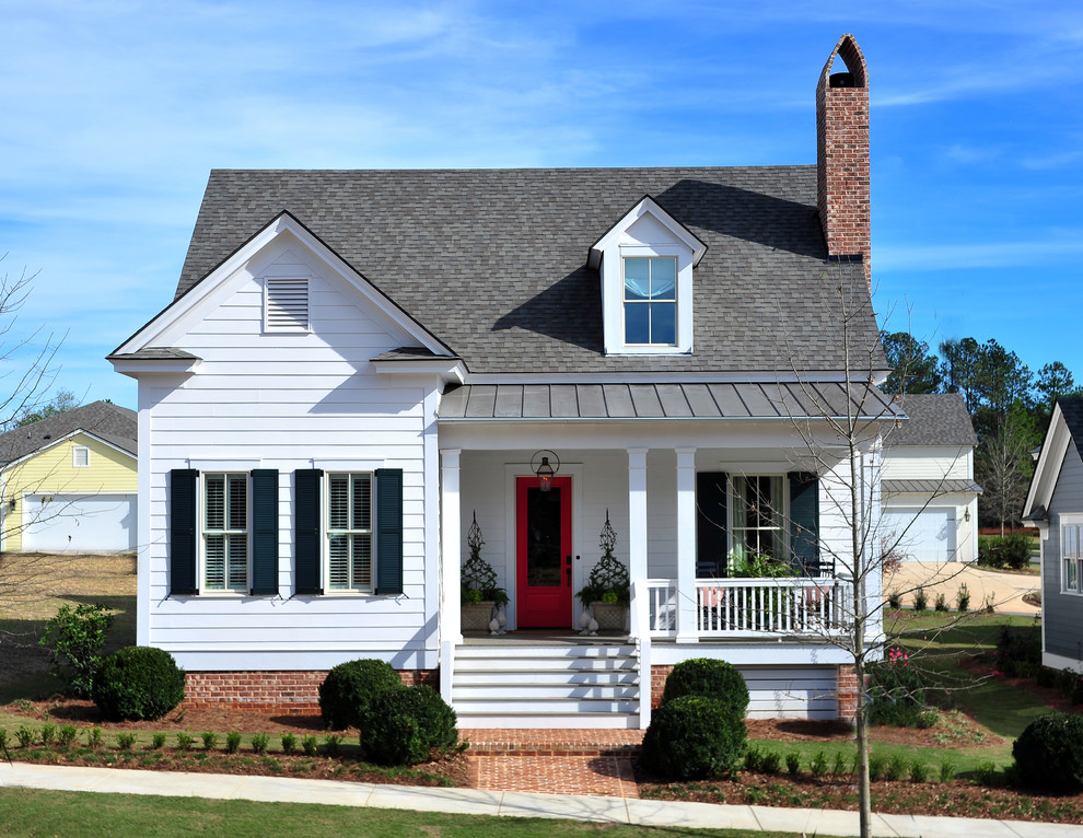 Cette photo montre une façade de maison blanche chic en béton avec un toit à deux pans.
