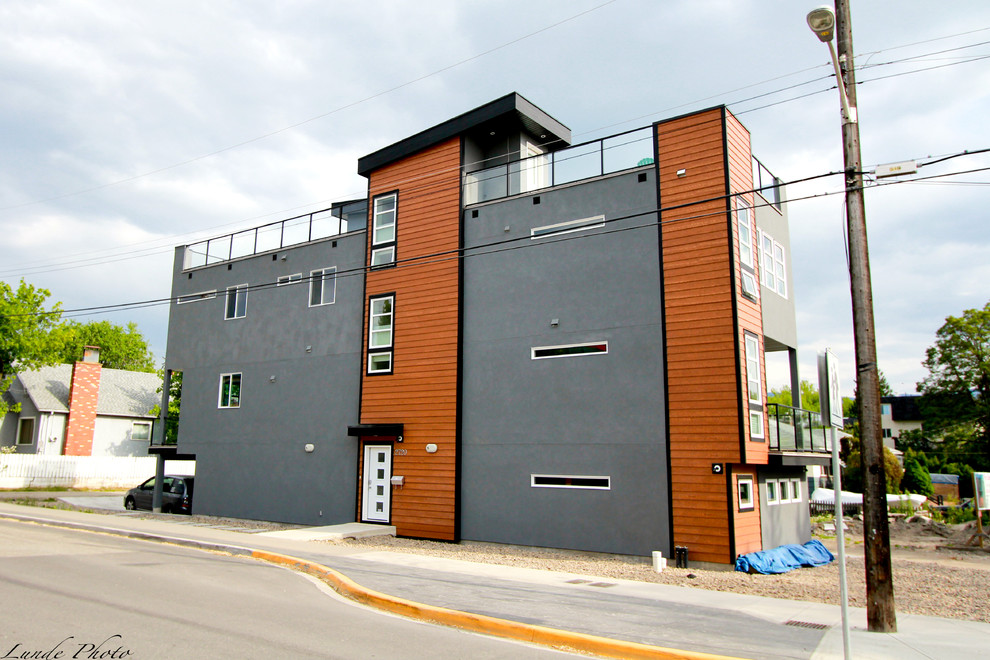 Cette image montre une façade de maison grise minimaliste en stuc de taille moyenne et à deux étages et plus.