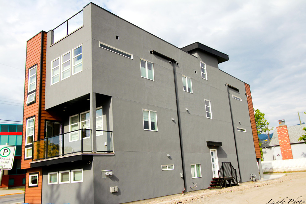 Cette photo montre une façade de maison grise moderne en stuc de taille moyenne et à deux étages et plus.