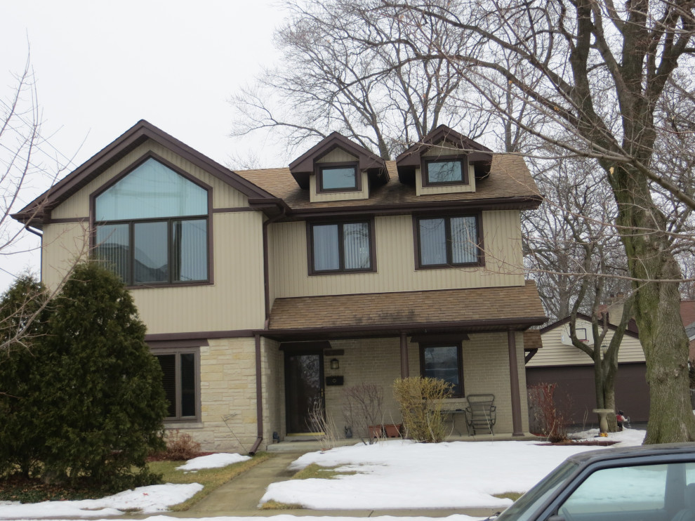 Example of a mid-sized classic beige two-story vinyl exterior home design in Chicago with a shingle roof