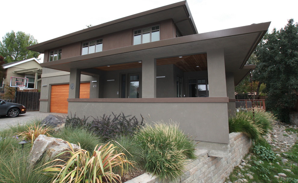 Пример оригинального дизайна: двухэтажный, коричневый дом в стиле модернизм с облицовкой из цементной штукатурки