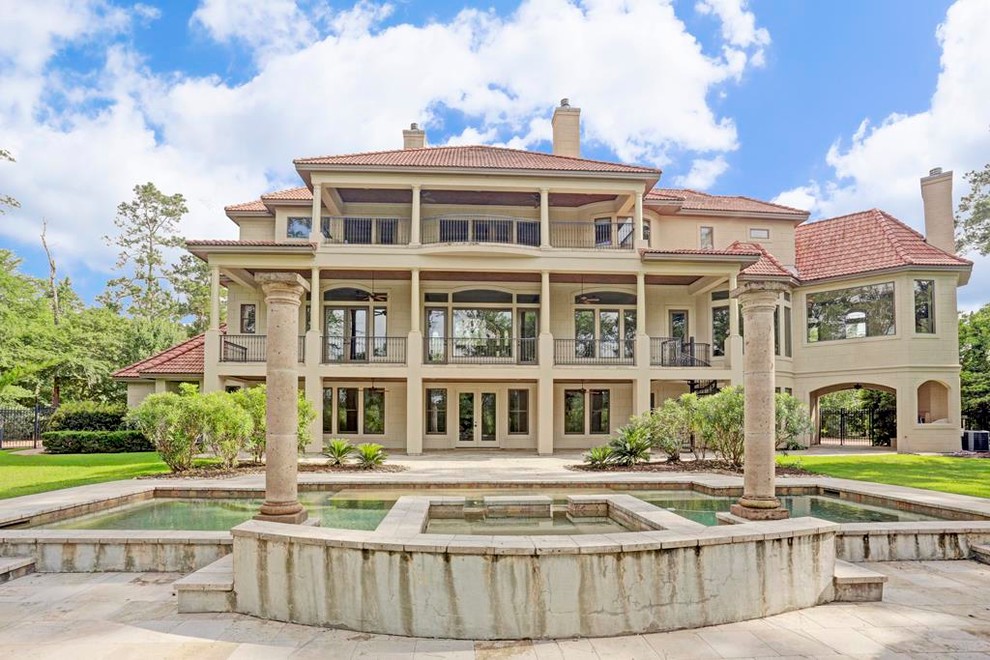 Geräumiges, Dreistöckiges Mediterranes Einfamilienhaus mit Putzfassade, weißer Fassadenfarbe, Walmdach und Ziegeldach in Houston