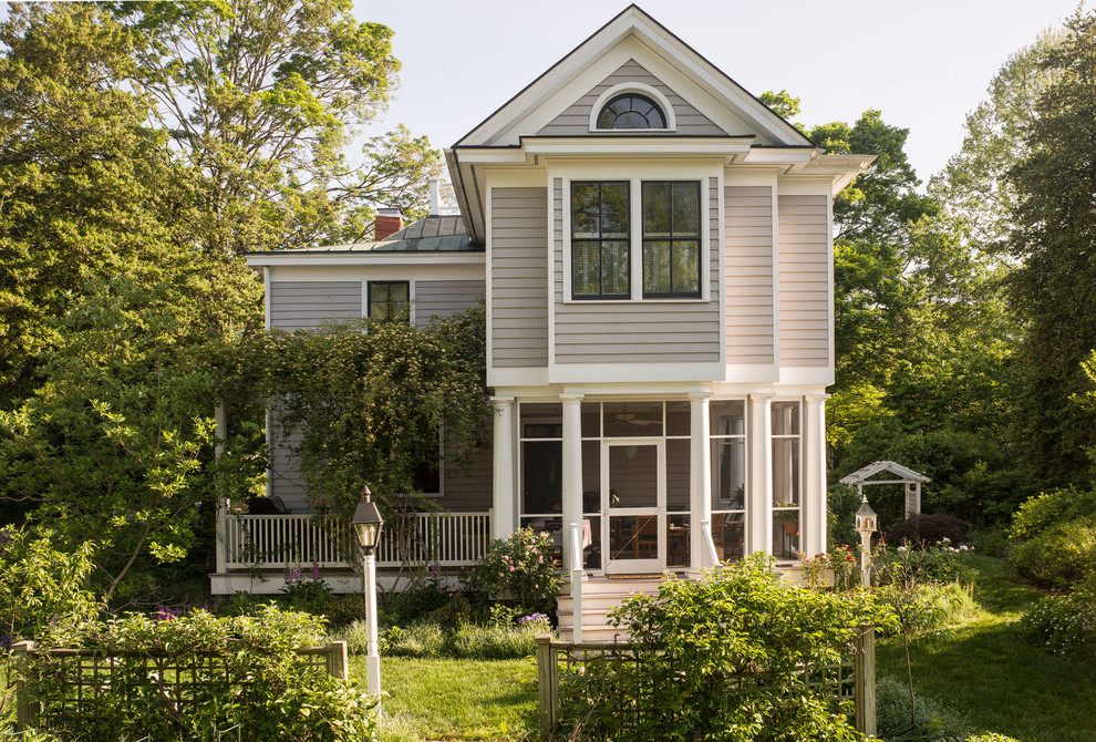 Cette photo montre une façade de maison grise chic en bois de taille moyenne et à un étage avec un toit à deux pans.