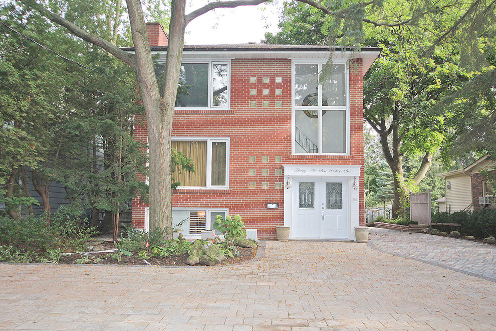 Mittelgroße, Zweistöckige Klassische Doppelhaushälfte mit Backsteinfassade, roter Fassadenfarbe, Satteldach und Schindeldach in Toronto