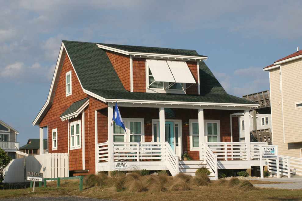 Cette image montre une façade de maison marron marine en bois de taille moyenne et à un étage avec un toit à deux pans.