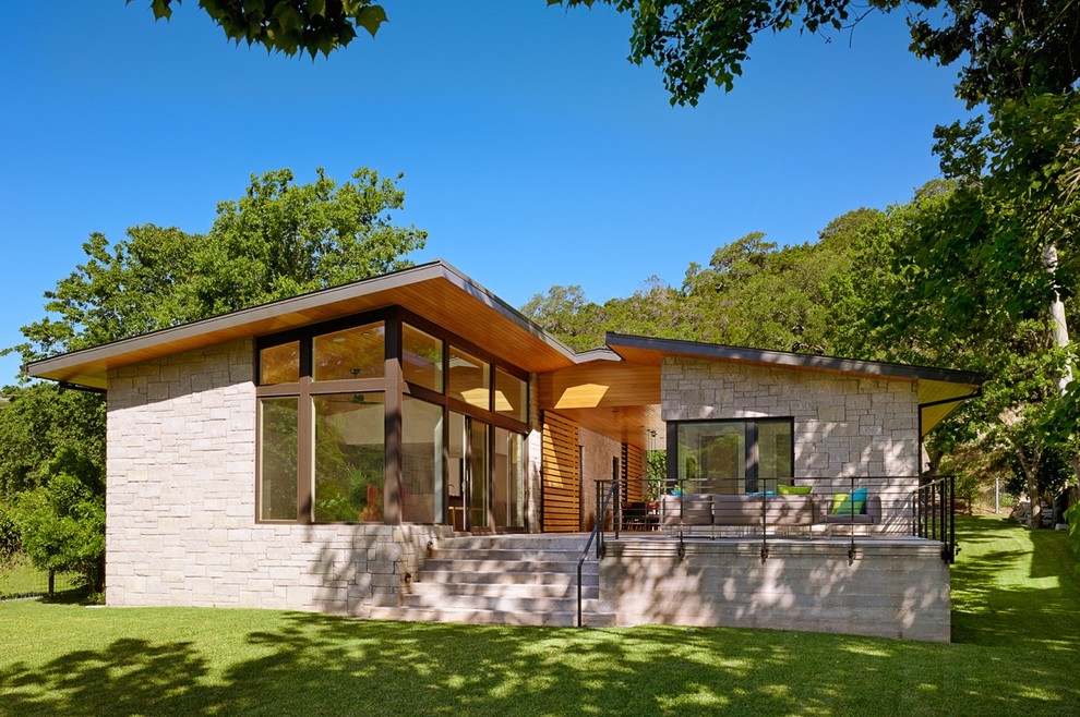Mittelgroßes, Zweistöckiges Modernes Haus mit Steinfassade und grauer Fassadenfarbe in Austin