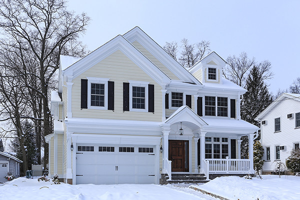 Esempio della facciata di una casa grande beige moderna a due piani con rivestimento in legno e tetto a capanna