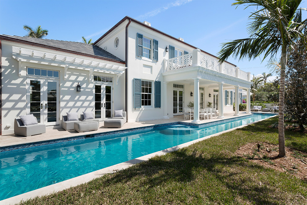 Mid-sized beach style white two-story concrete house exterior photo in Miami with a hip roof and a shingle roof