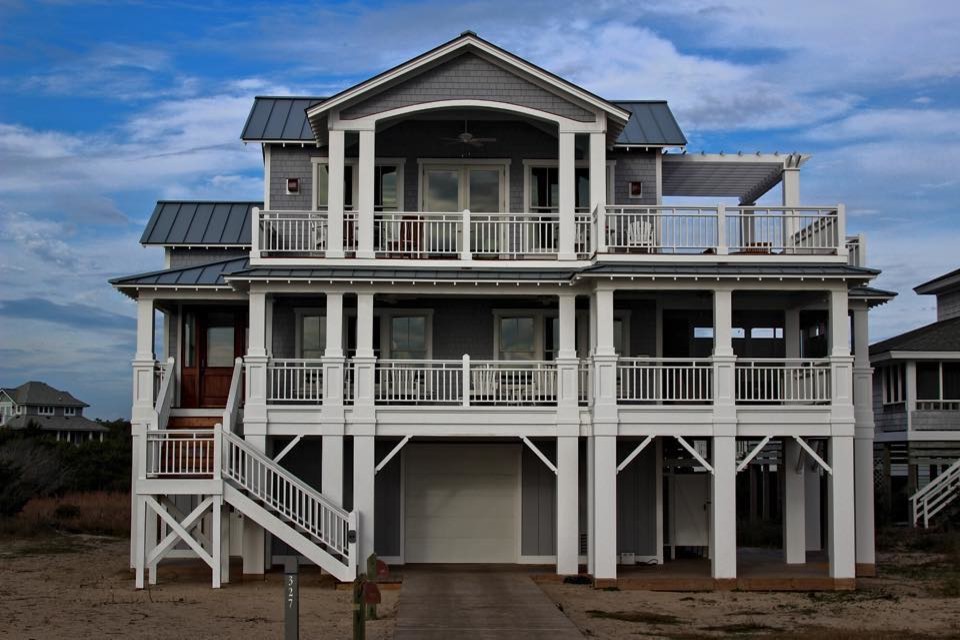 Foto de fachada de casa gris costera grande de tres plantas con revestimiento de madera, tejado a dos aguas y tejado de metal