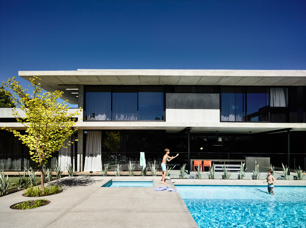 Großes, Dreistöckiges Modernes Haus mit Betonfassade und grauer Fassadenfarbe in Melbourne