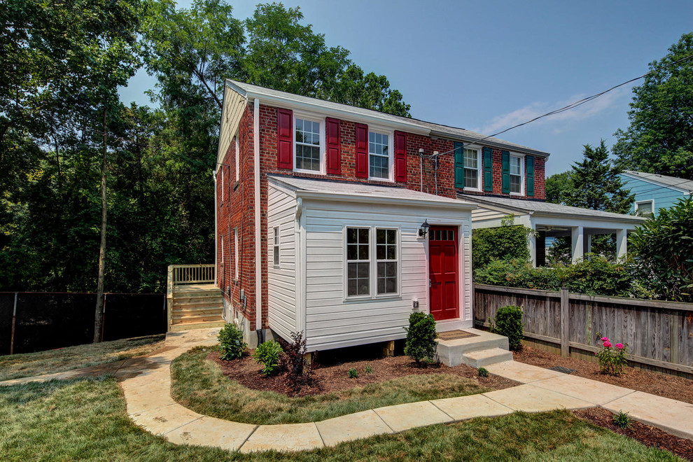 Cette photo montre une façade de maison rouge chic en brique à deux étages et plus.