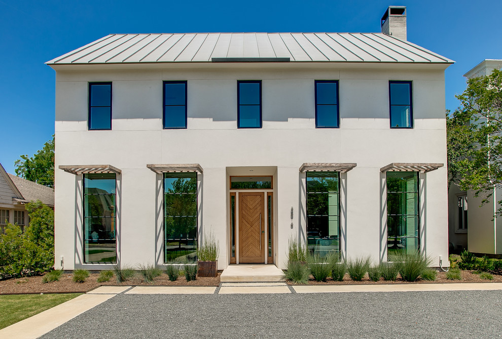 Modelo de fachada de casa beige tradicional renovada de dos plantas con tejado a cuatro aguas y tejado de metal