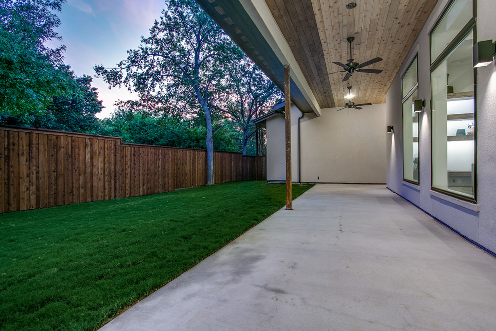 Immagine di un patio o portico moderno di medie dimensioni e dietro casa con lastre di cemento e un tetto a sbalzo