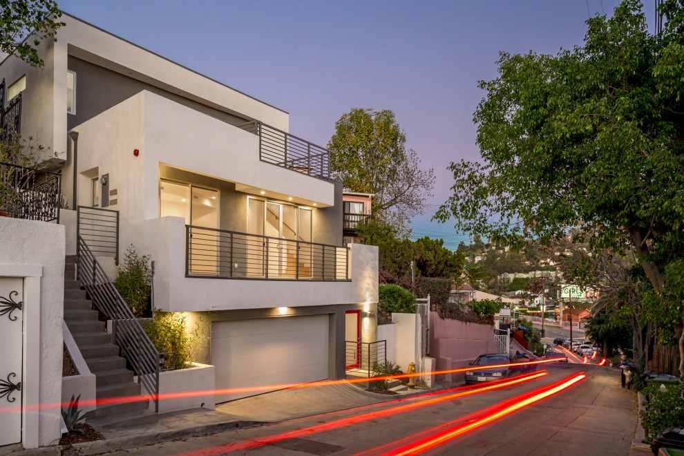 Kleines, Dreistöckiges Modernes Einfamilienhaus mit Putzfassade, weißer Fassadenfarbe und Flachdach in Los Angeles