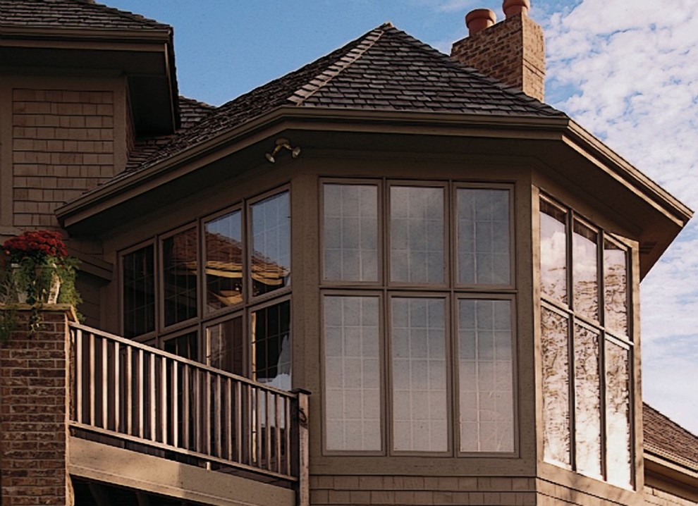Ispirazione per la facciata di una casa marrone classica con rivestimento in legno, tetto a padiglione e copertura a scandole