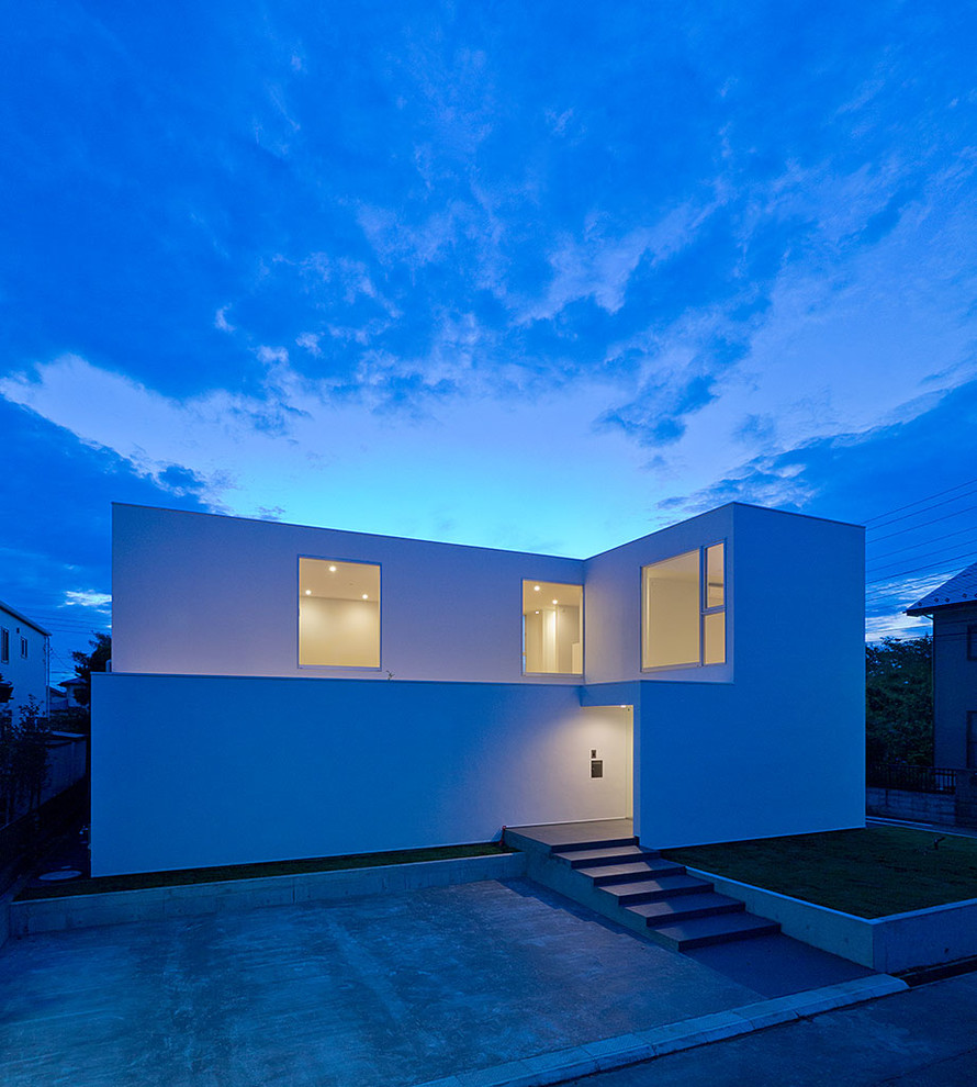 Idée de décoration pour une façade de maison blanche minimaliste de taille moyenne et à un étage.