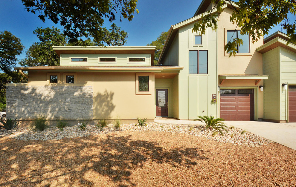 Example of a mid-sized transitional green two-story mixed siding exterior home design in Austin with a shed roof