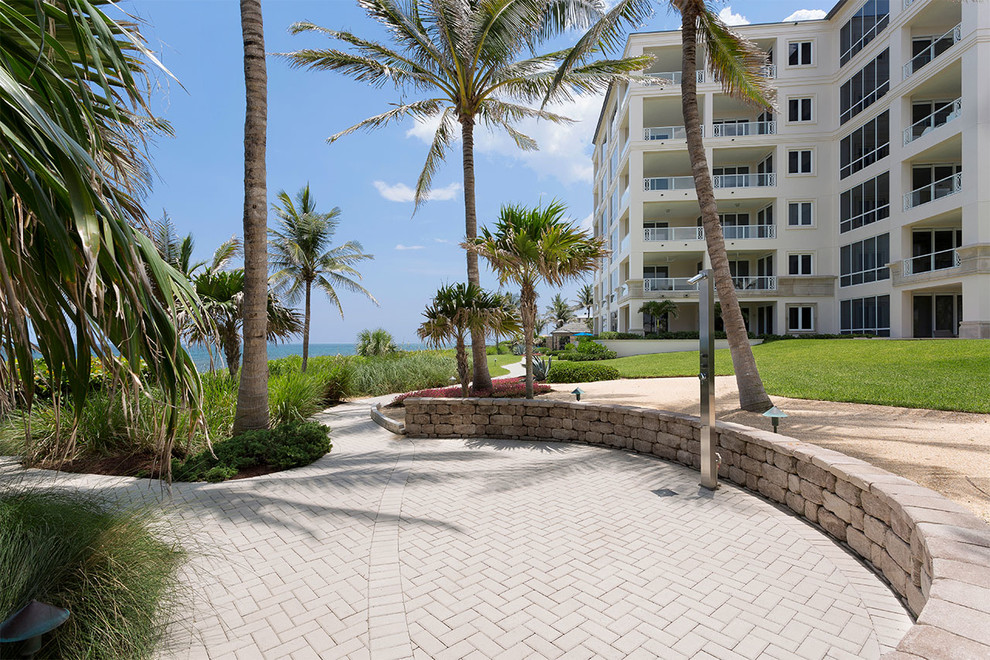 Mid-sized beach style white three-story concrete apartment exterior photo in Miami with a shed roof and a tile roof