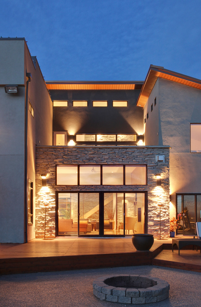 Trendy two-story stucco exterior home photo in Calgary with a shed roof