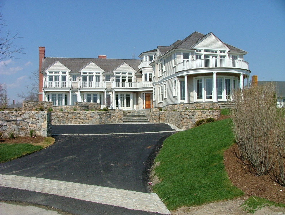 Large beach style gray two-story wood house exterior photo in Providence with a hip roof and a shingle roof