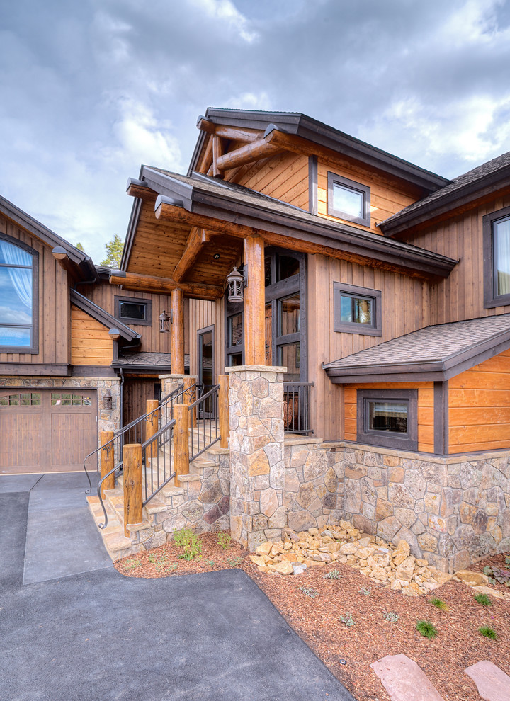 Rustic stone exterior home idea in Denver
