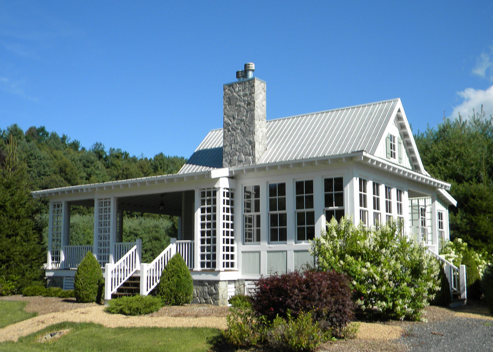 Esempio della facciata di una casa piccola country a un piano con rivestimento in legno