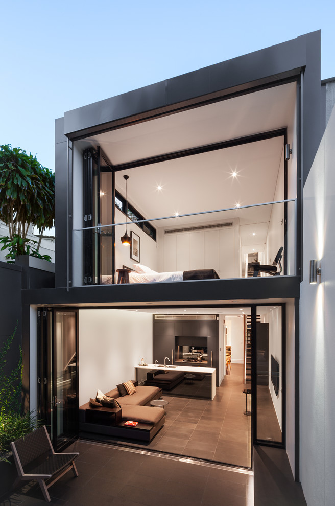 Medium sized and black contemporary two floor house exterior in Other with a flat roof.