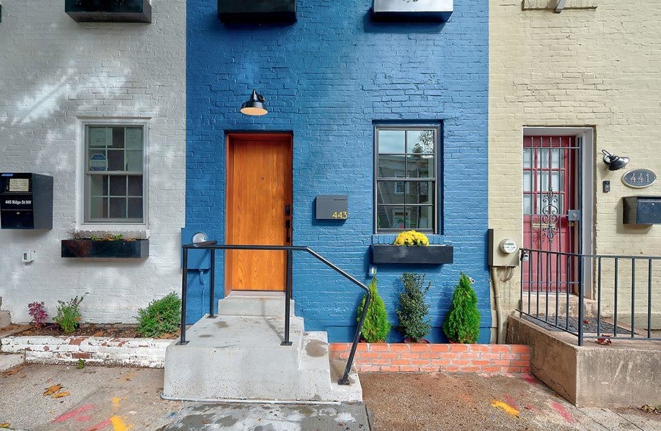 Cette image montre une façade de maison de ville bleue design en brique de taille moyenne et à deux étages et plus.