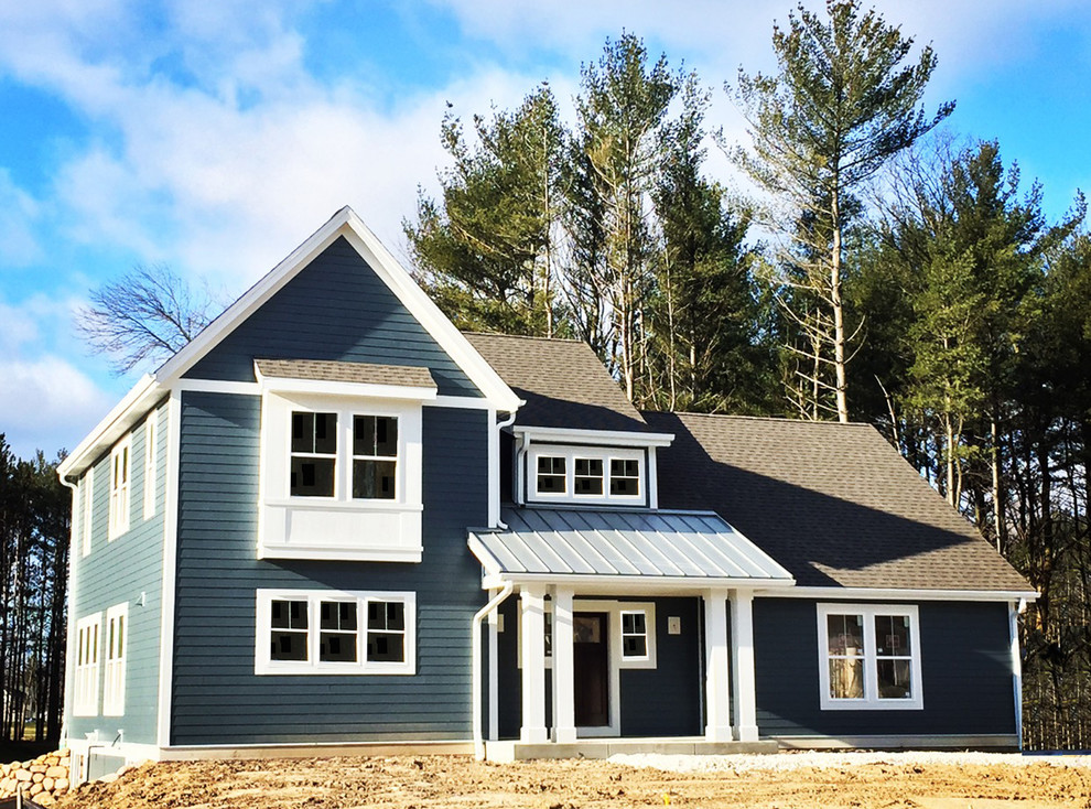 Mittelgroßes, Zweistöckiges Landhaus Haus mit Vinylfassade, blauer Fassadenfarbe und Satteldach in Milwaukee