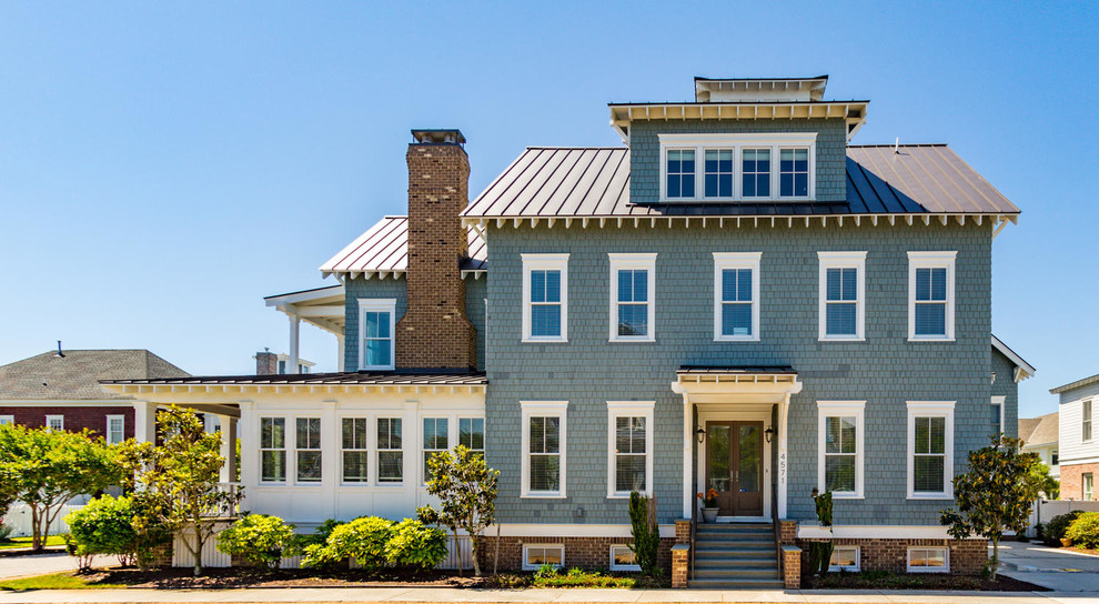 Aménagement d'une façade de maison verte bord de mer à un étage avec un revêtement mixte, un toit à deux pans et un toit en métal.