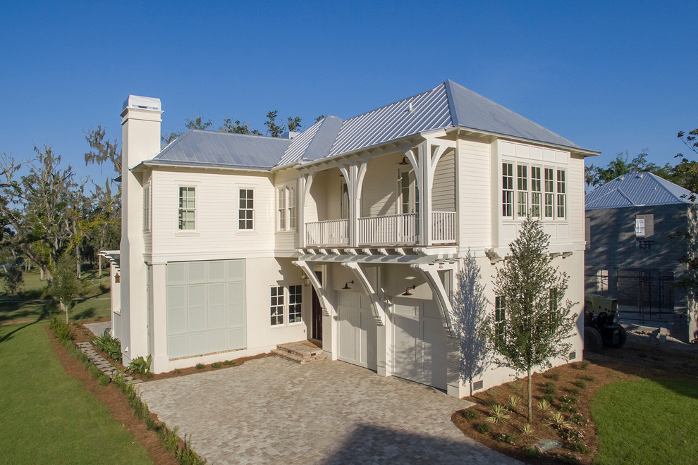 Mid-sized elegant white two-story mixed siding exterior home photo in Miami with a hip roof