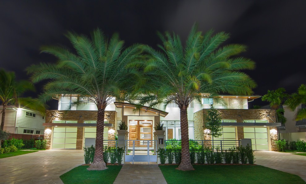 This is an example of a large and beige modern two floor house exterior in Miami with stone cladding.