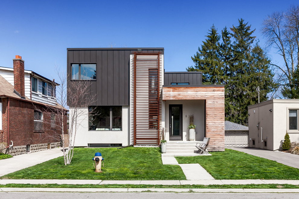 Diseño de fachada gris actual de tamaño medio de dos plantas con tejado plano y revestimientos combinados