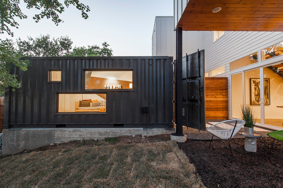 На фото: большой, двухэтажный дом из контейнеров, из контейнеров в стиле модернизм с облицовкой из металла и плоской крышей