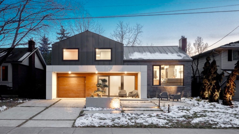 Diseño de fachada de casa negra minimalista de tamaño medio de dos plantas con revestimiento de metal, tejado a dos aguas y tejado de metal