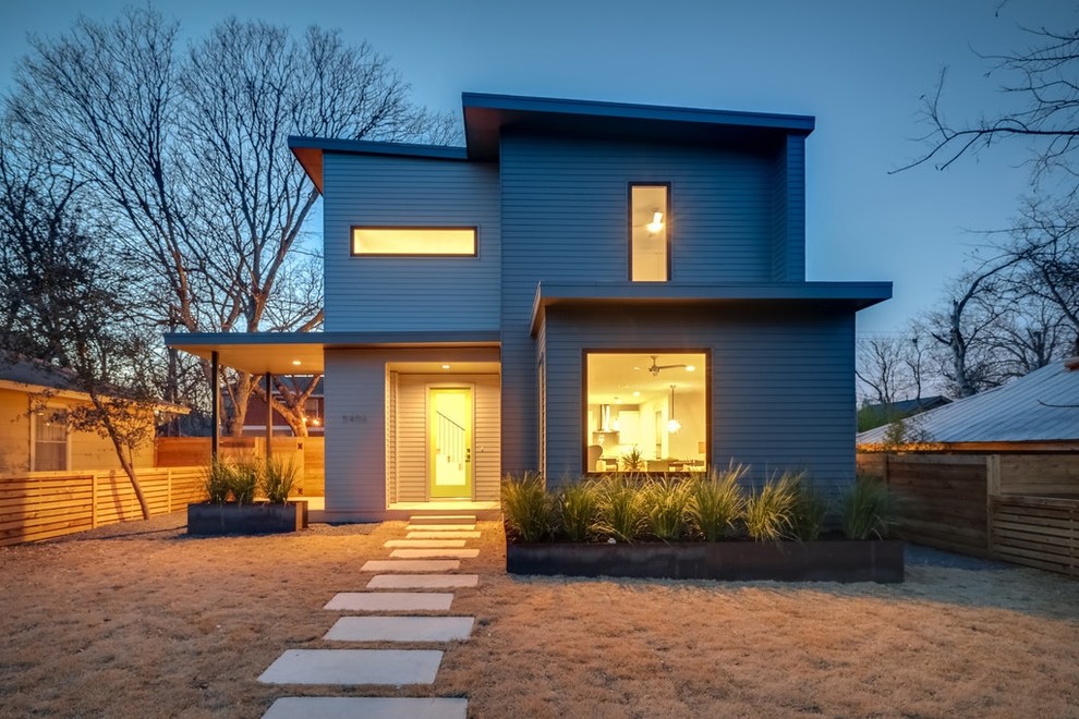 Ejemplo de fachada de casa gris retro de tamaño medio de dos plantas con revestimiento de madera, tejado plano y techo verde