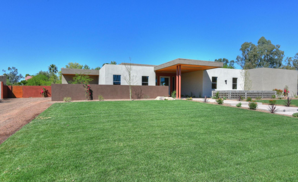 Foto de fachada de casa beige, contemporánea, extra grande, de una planta, con revestimiento de estuco, tejado plano y techo verde