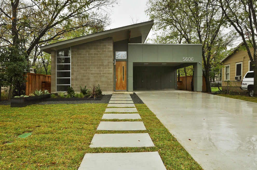 Inspiration for a small mid-century modern one-story concrete exterior home remodel in Austin