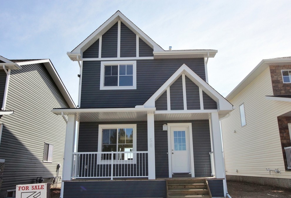 Foto della facciata di una casa piccola blu american style a due piani con rivestimento in vinile e tetto a capanna