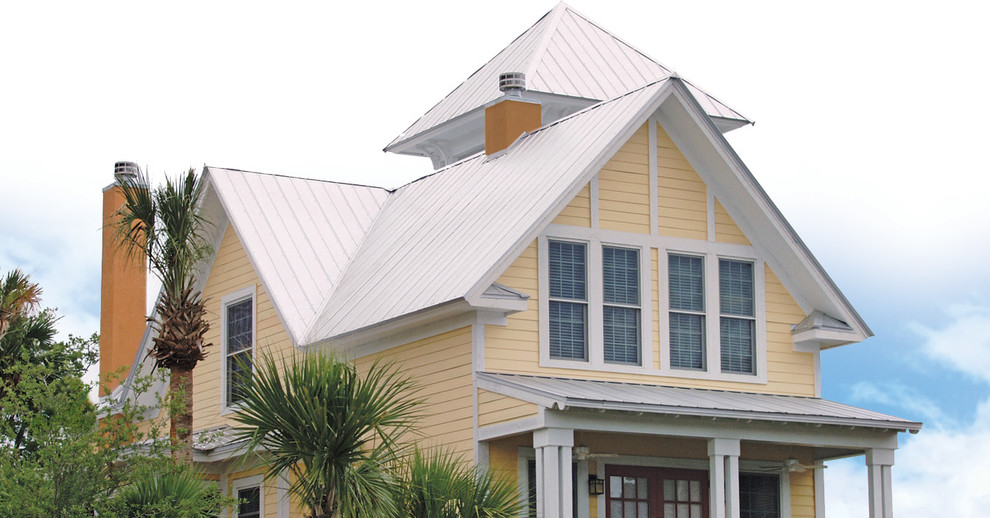 Пример оригинального дизайна: двухэтажный, деревянный, желтый дом среднего размера в морском стиле с двускатной крышей