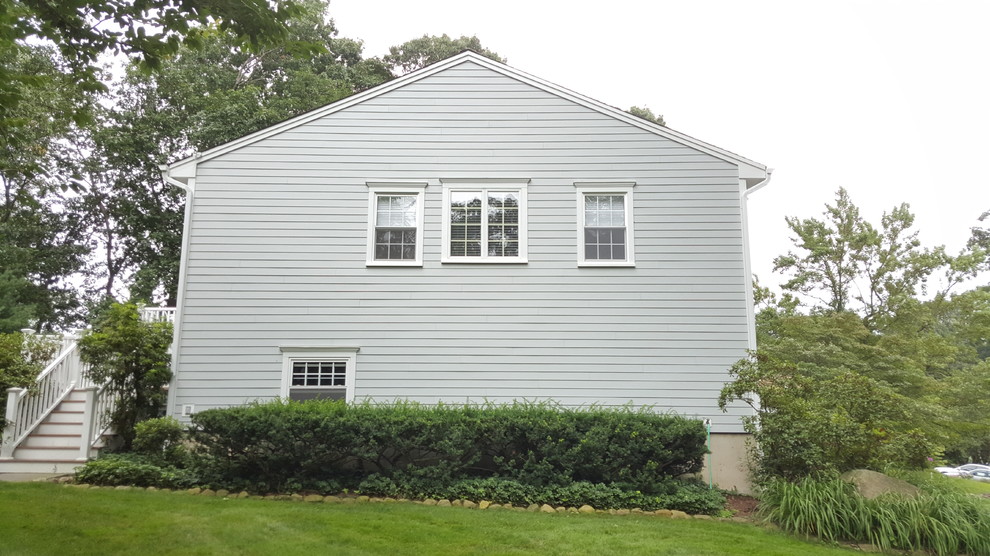 Cette image montre une façade de maison grise traditionnelle en panneau de béton fibré à un étage et de taille moyenne avec un toit à deux pans et un toit en shingle.
