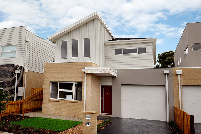 Modelo de fachada de casa pareada beige moderna de tamaño medio de dos plantas con revestimiento de ladrillo, tejado a dos aguas y tejado de metal