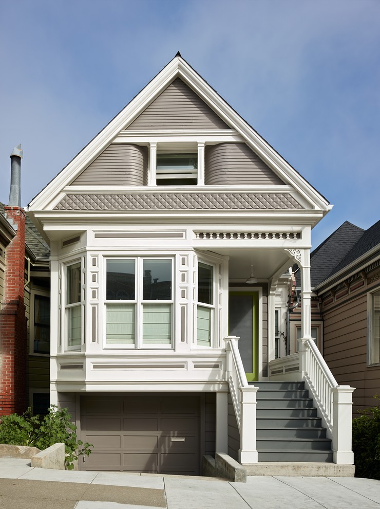Пример оригинального дизайна: двухэтажный, серый дом в викторианском стиле с двускатной крышей
