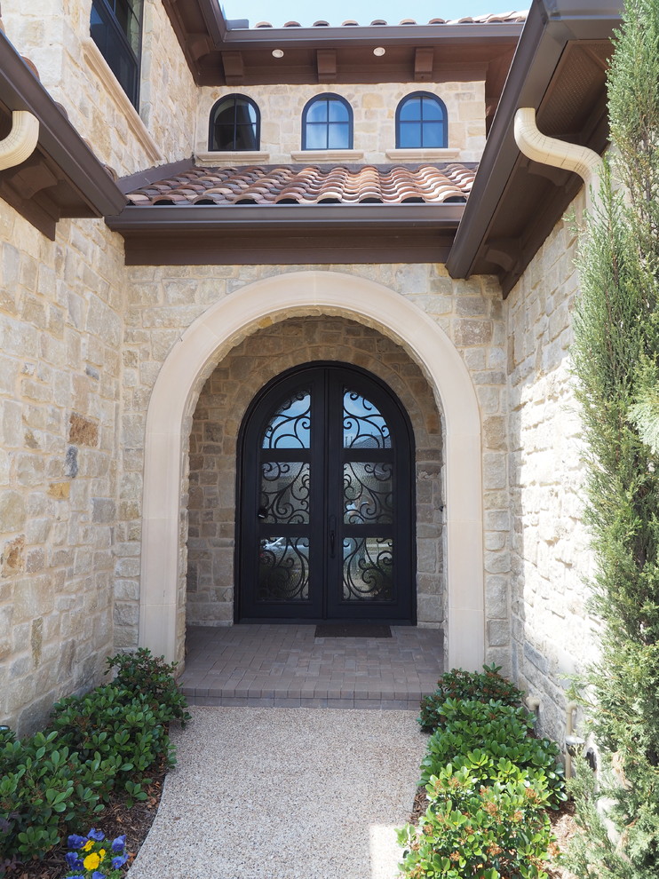 Inspiration for a large and beige mediterranean two floor house exterior in Dallas with stone cladding and a hip roof.