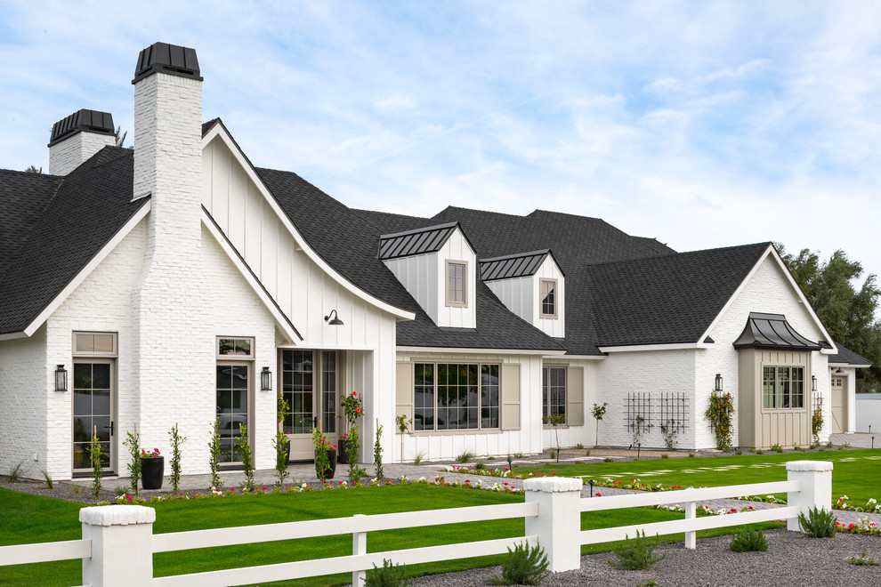 Example of a cottage white one-story mixed siding exterior home design in Phoenix with a shingle roof