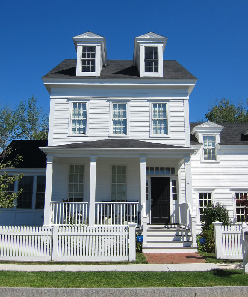 Esempio della facciata di una casa bianca classica a due piani con rivestimento in legno e tetto a capanna