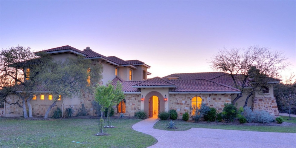 Geräumiges, Dreistöckiges Mediterranes Einfamilienhaus mit Steinfassade, beiger Fassadenfarbe, Walmdach und Ziegeldach in Austin